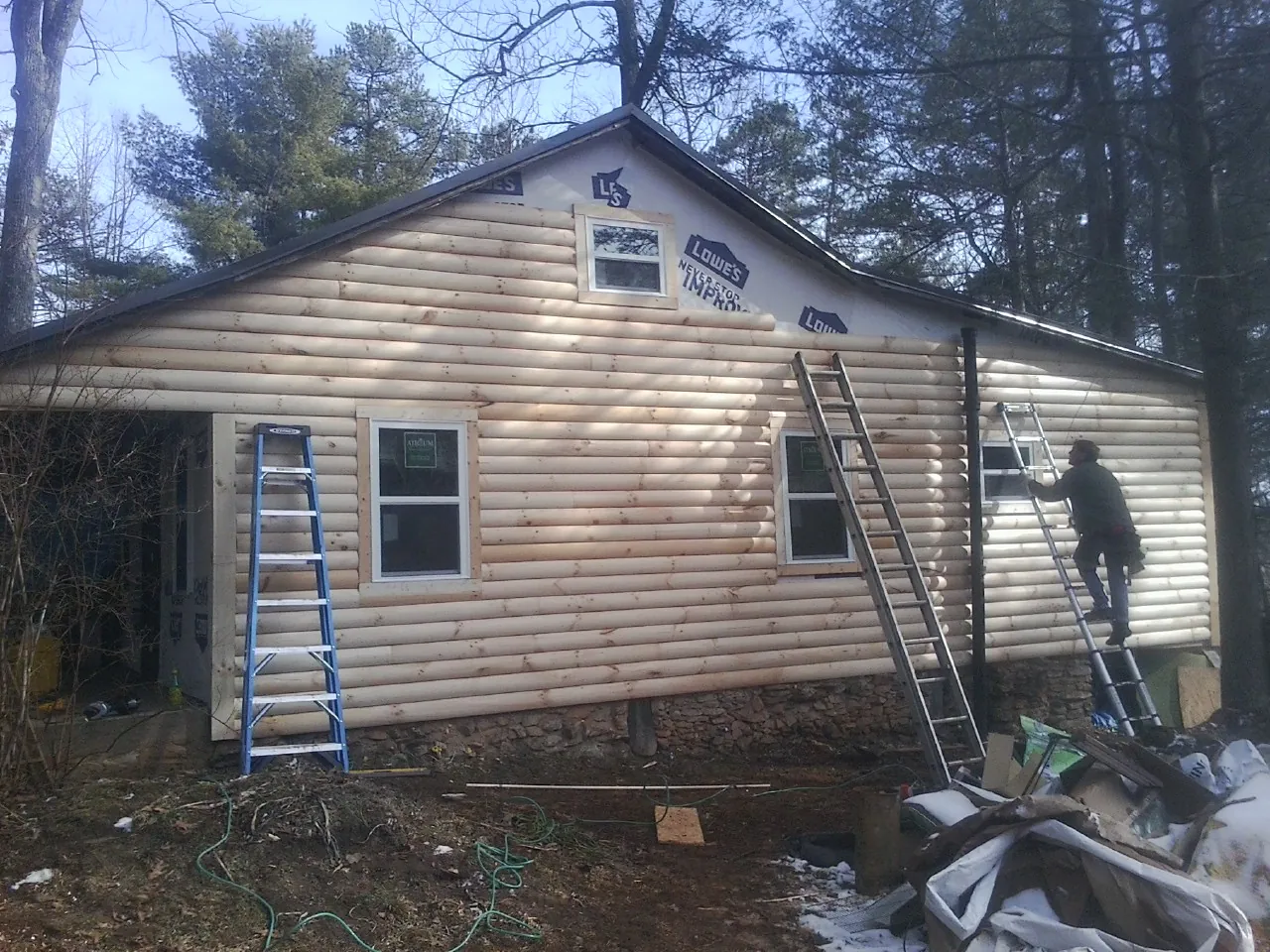 Ladders set against fresh log siding during an exterior remodel in Plymouth Meeting