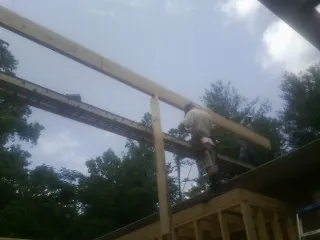 Carpenter setting a ridge beam over a new addition frame — Ice Dam Removal by Roofing Brothers in Plymouth Meeting