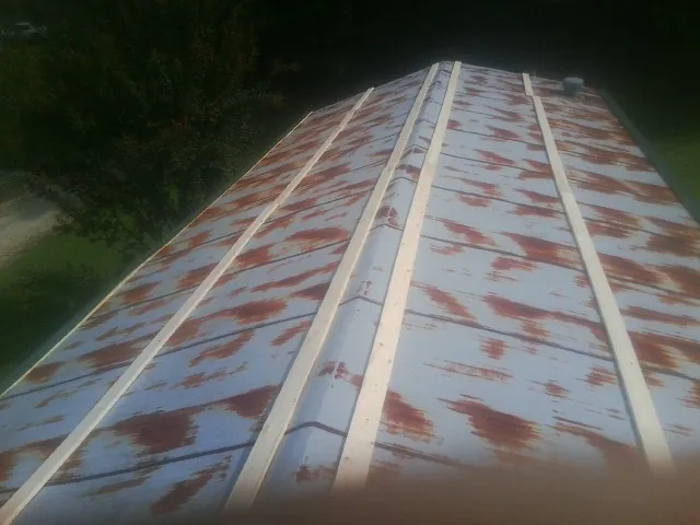 Rusted metal roof panels with new wood purlins before replacement — Storm Damage Roof Repair in Plymouth Meeting by Roofing Brothers
