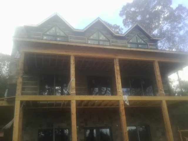 Dormers and porch framing on a large log home under construction — Roof Coating work by our crew in Plymouth Meeting