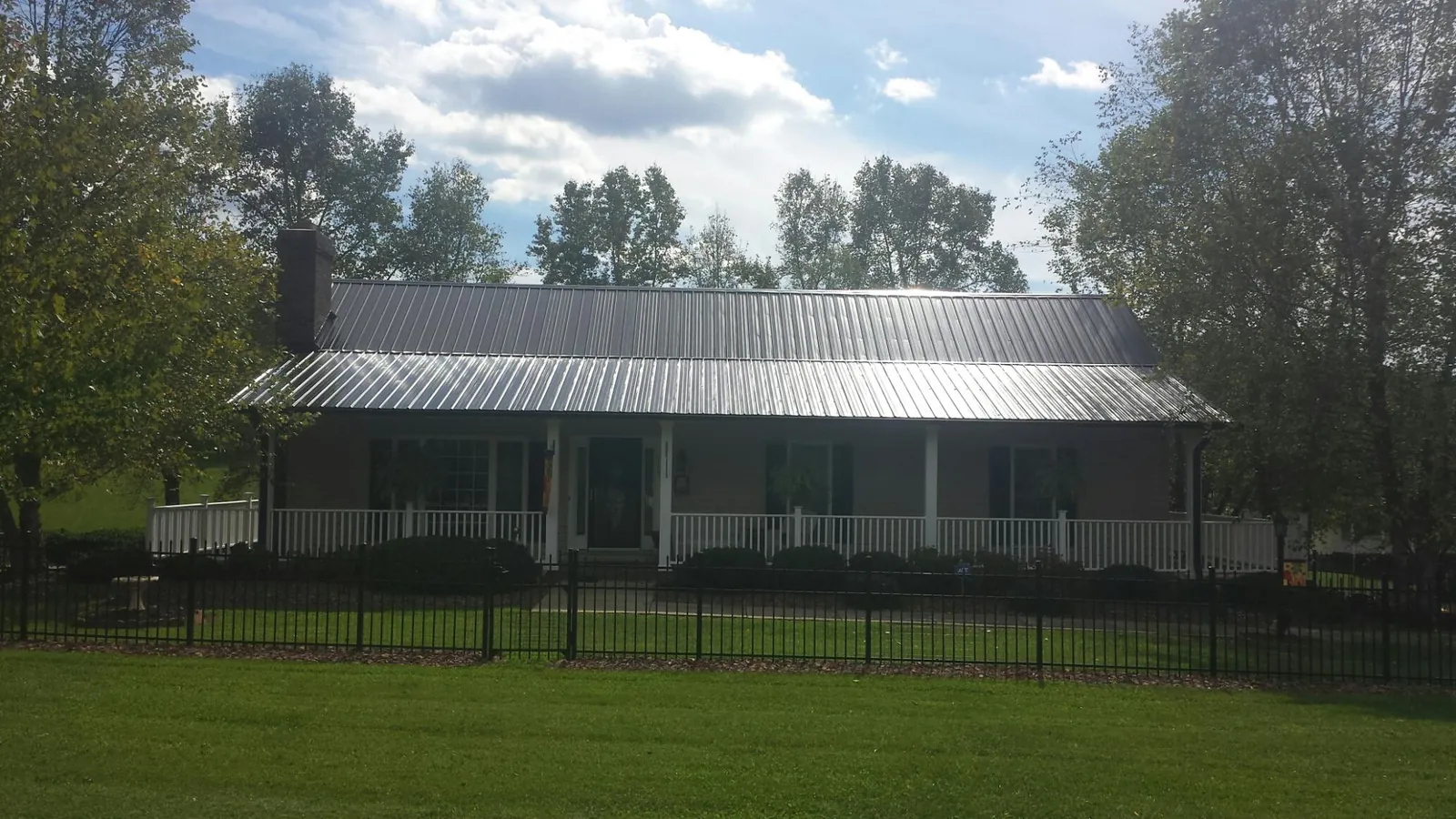Gray metal roof on a brick ranch with a full width front porch — Gutter Guard Installation work by our crew in Plymouth Meeting