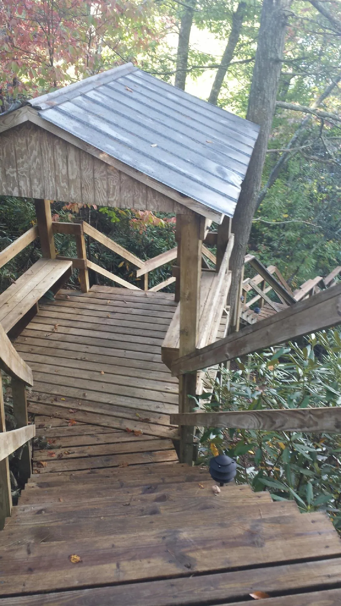 Metal roofed shelter over wooden steps on a wooded walkway — Skylight Repair & Installation work by our crew in Plymouth Meeting